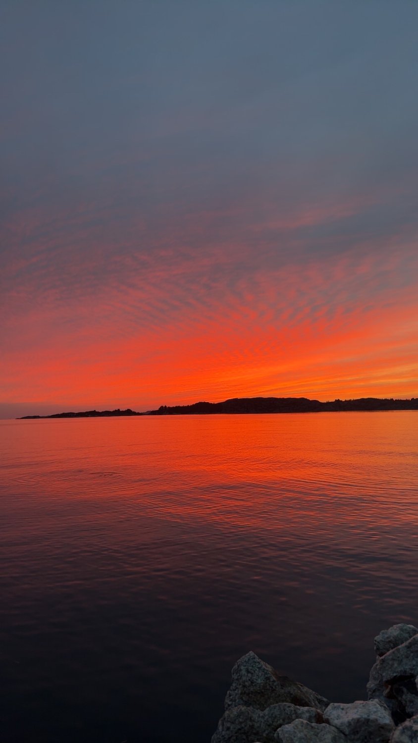 A blazing red sunset over the fjord at Austevoll